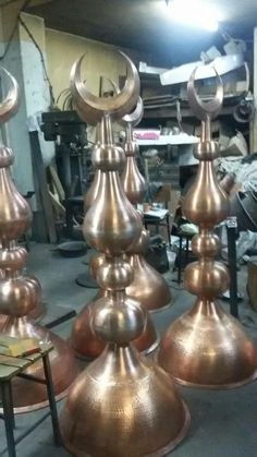 several large metal pots sitting on top of each other in a room filled with tools