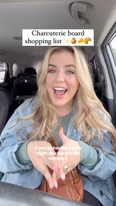 a woman sitting in the back seat of a car with her hand up and smiling