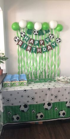 a soccer themed birthday party with green and white balloons, streamers, and decorations