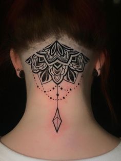 a woman's neck with a black and white tattoo design on it