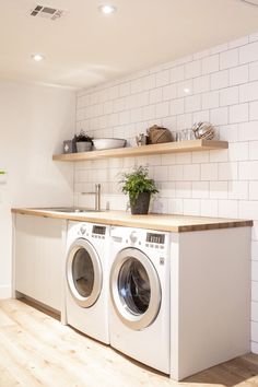 a washer and dryer in a room with white tiles on the back wall