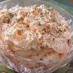 a glass bowl filled with mashed potatoes and herbs