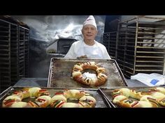 a woman standing in front of trays of hot dogs and buns