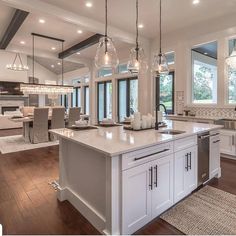 a large kitchen with an island in the middle and lots of lights hanging from the ceiling