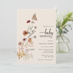 an elegant bridal shower card with flowers and butterflies on the front is displayed next to a vase full of baby's breath