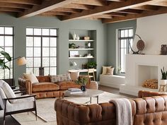 a living room with couches, chairs and fireplace in the middle of the room