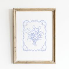 a blue and white drawing of flowers in a frame