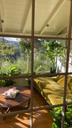 a couch sitting on top of a wooden floor next to a table with a cup