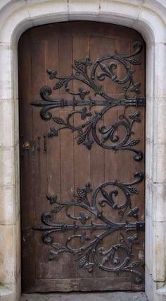 an old wooden door with iron work on it