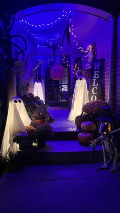 halloween decorations on display in front of a house with purple lights and ghost bags hanging from the ceiling