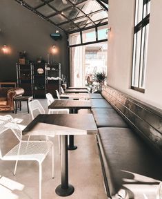 tables and chairs are lined up in a room with large windows on the side wall