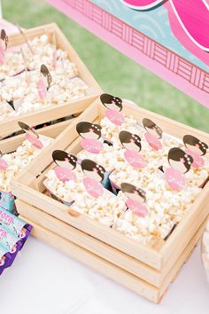 two wooden trays filled with cake and marshmallows on top of a table