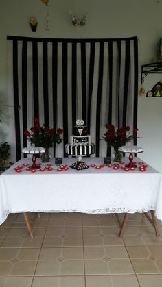 the table is decorated with red roses and black stripes