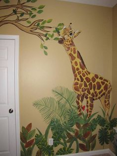 a giraffe painted on the side of a wall next to a tree with leaves