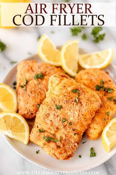 air fryer fried fish fillets on a plate with lemons and parsley