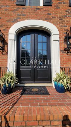 the front entrance to clark hall doors with two planters on each side and one door open