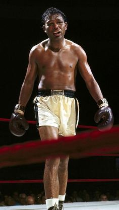 a man standing in the middle of a ring wearing boxing gloves