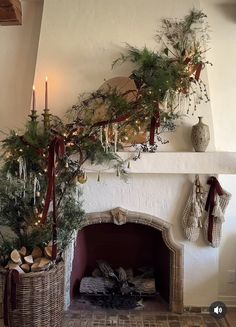 a fireplace decorated with christmas greenery and stockings