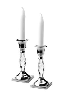 two crystal candlesticks sitting on top of each other with one candle in the middle