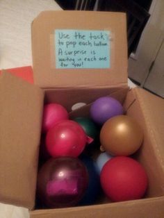 a cardboard box filled with different colored ornaments