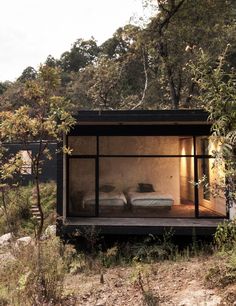 a small cabin with two beds in the woods