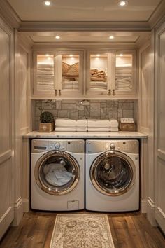 a washer and dryer in a small room with wood flooring, built - in cabinets and drawers