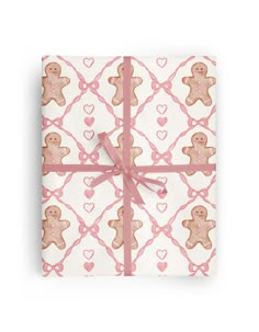 a gift wrapped in pink and white wrapping paper with a teddy bear design on it