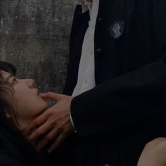 a woman laying on the ground next to a man in a black suit and tie