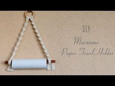 a paper towel holder hanging on the wall with some rope attached to it that says, diy marrome paper towel holder