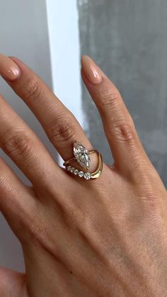 a woman's hand with a gold ring and two diamond rings on her fingers