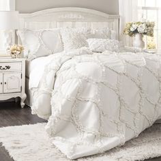 a bed with white comforter and pillows on the bottom is shown in this ad