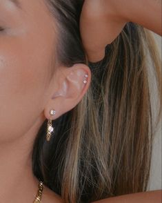 a close up of a person wearing some kind of earring with pearls on it