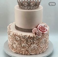 a three tiered cake with roses and a crown on top