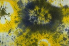 an abstract tie - dyed background with yellow, blue and green circles in the center