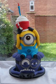 a cake that looks like a minion with a birthday hat on