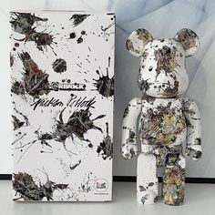 a white and black bear next to a box with paint splattered on it