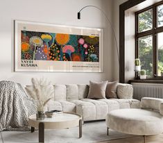 a living room filled with furniture and a large painting hanging on the wall above it