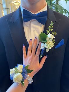 a man in a tuxedo with flowers on his lapel and two rings