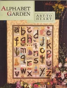 the alphabet quilt pattern is displayed in front of some flowers and potted planters