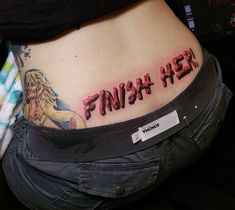 a woman's stomach with the word finish her tattooed on it