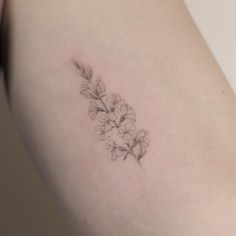 a small tattoo on the back of a woman's left arm, with flowers growing out of it