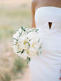 a bridal holding a bouquet of white flowers