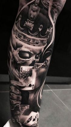 a man's leg with tattoos on it and a skull wearing a crown in the middle