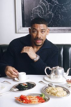 a man sitting at a table with food on it