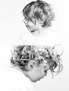 two young children are looking at each other in black and white, while one child has curly hair on her head