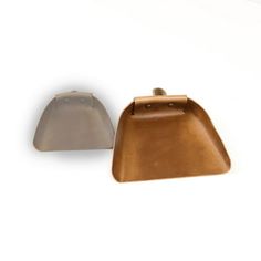 two pieces of brown leather sitting next to each other on a white surface with one piece missing