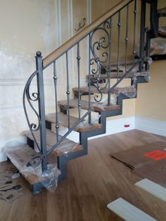 a stair case in the middle of a room with wood flooring and paint on the walls