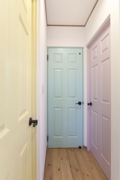 an empty hallway with two doors and wood flooring on either side of the door