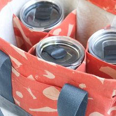 four soda cans in an orange and white bag