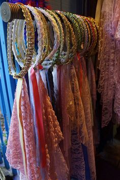 many different colored bracelets are hanging on a rack in front of a blue door